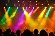 © Lensa - Colorful stage lights illuminate a crowd at a live music event.