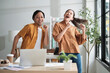 © tigercat_lpg - Happy working in casual small business office. Two Asian startup company colleagues enjoy dancing and singing songs together, relaxing from freelance jobs, humor, and funny coworker team in workplace.