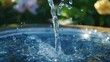© Anastasiia - A dynamic shot of water splashing into a vibrant blue surface, set against a lush, green garden background. The crisp movement of water droplets captures the essence of freshness and vitality, ideal