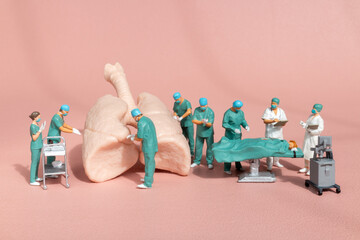 Wall Mural - Miniature figures, medical team performing surgery on a detailed anatomical lung model