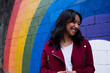 © Westend61 - Happy woman standing near multi colored wall