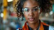 © alva studio - Confident young female engineer wearing safety glasses in a factory.
