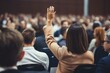 © nsit0108 - Businesswoman asking question during a conference q and a session, raising her hand to participate