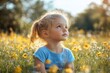 © Bojan - Young child gazing thoughtfully at the sky among wildflowers in a sunny field