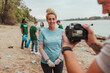 © bernardbodo - Videographer filming volunteer during river cleanup event