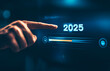 © GustavsMD - Progress to 2025 concept. A person pointing to loading bar transitioning to 2025, progress, future planning, and new year goals. annual planning and business growth