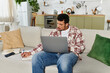 © LIGHTFIELD STUDIOS - Man engaged in work on a laptop while seated comfortably on a sofa at home.