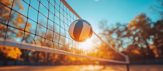 Wall Mural - Volleyball in net at sunset.