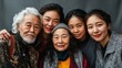 © Adi - people of different ages and ethnicities stand close together in front of a gray backdrop, all smiling and looking directly at the camera