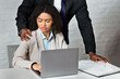 © Prostock-studio - Sexual harassment in office concept. African American boss molesting his female employee at workplace