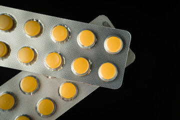 Wall Mural - Brown Yellow Tablet pills blister Medicine on a black background