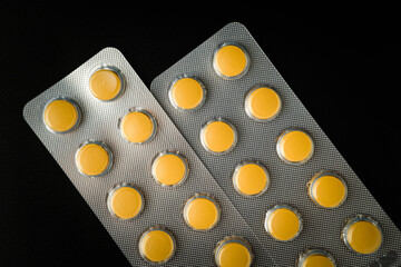 Wall Mural - Brown Yellow Tablet pills blister Medicine on a black background