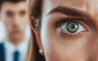 © Happy Photo Stock - Gaslight manipulation toxic narcissism and abuse psychology concept. Close-up of a woman's eye with a tense expression, while a blurred man stands behind her, creating a sense of intrigue and tension.