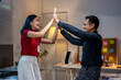 © Wasana - Business people celebrating success with high five in office at night