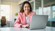 © Nii_Anna - Women wearing pink. Woman in pink blazer working on laptop in modern office setting