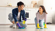 © Prostock-studio - Young asian couple cleaning floor together at kitchen and having conversation. Happy millennial man and woman house-keeping together at weekend, rubbing floor with dust cloth and cleaning sprays