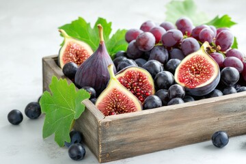 Wall Mural - Old wooden crate overflowing with fresh figs, dark grapes, and pomegranates surrounded by green leaves in soft shadow