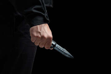 Wall Mural - Criminal holding a knife closeup, armed attack concept.