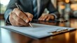 © olegganko - Individual signing documents with a miniature house on the table during a financial agreement