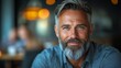 © olegganko - Smiling man with gray hair in a cozy cafe during an evening gathering