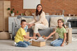 © Pixel-Shot - Mother and her children putting toys in wicker basket at home