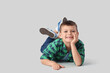 © Pixel-Shot - Cute little boy lying on light background