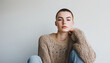 © Soloviova Liudmyla - Portrait of nonbinary person expressing masculine energy with confident pose, short hair, stylish knited sweater with holes, studio shoot, strong posture, and self-assured expression