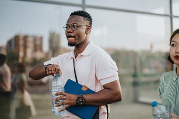 Wall Mural - A diverse group of business professionals taking a refreshing break outside an office building in the city. The image captures a moment of relaxation and camaraderie among colleagues.