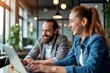 © NeedMoreMars - Collaborative Office Environment: Two Professionals Working Together on Laptop in Modern Workspace, Ideal for Teamwork and Productivity