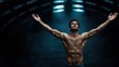 © Evgenii - muscular man stands confidently with arms outstretched in a gym setting. low light highlights his defined physique, showcasing strength and determination during a workout