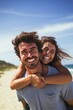 © Mountains Hunter - Happy man giving piggyback ride to woman at beach. Young people full of joy on vacation. Generative AI.