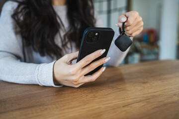 unknown woman hold wireless location accessory token to locate keys