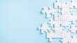 © Thitiporn - White Puzzle Pieces on Blue Background: A close-up of scattered white puzzle pieces arranged on a calming blue background, symbolizing the concept of connection, problem-solving.