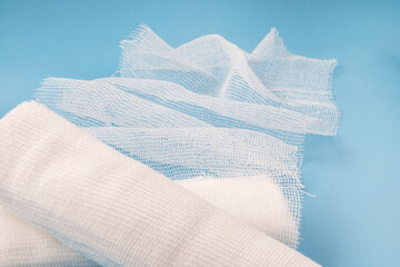 Gauze medical bandage. Bandages on a blue background. Unwound bandage.