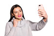 © deagreez - Pretty lady holding telephone hands making selfies wear warm knitted pullover isolated blue background