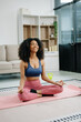 © Nuttapong punna - A young woman practices yoga and stretching with a mat and gym props, showcasing wellness, motivation,