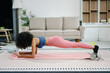 © Nuttapong punna - A young woman practices yoga and stretching with a mat and gym props, showcasing wellness, motivation,