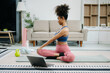 © Nuttapong punna - A young woman practices yoga and stretching with a mat and gym props, showcasing wellness, motivation,