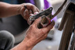 © Hào Lý - Mechanic sitting focused using wrench to repair motorcycle brake, drum brake pads at repair shop