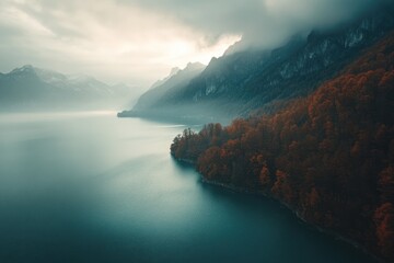 Poster - Serene lake surrounded by mountains and autumn foliage under a cloudy sky.