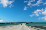 Drivers’ perspective over the Seven Mile Bridge or Florida State Road A1A towards Key West, FL, USA and cars on the road with on left side the Old Seven Mile Bridge