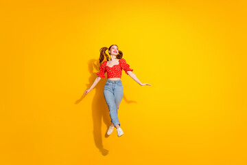 Wall Mural - Photo portrait of young red hair funky positive girl wearing blouse and jeans jumping positive isolated on yellow color background