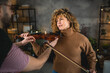 © Miljan Živković - boyfriend teach girlfriend how to play violin practice at home