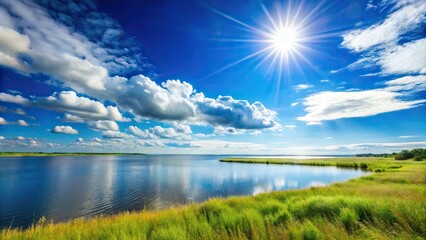 sunny waterfront prairie with bright blue skies reflection on water