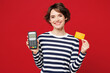 © ViDi Studio - Young smiling happy woman she wear blue striped sweatshirt casual clothes hold wireless modern bank payment terminal to process acquire credit card isolated on plain red background. Lifestyle concept.