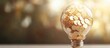© Alienmarsh - Light bulb filled with golden coins on blurred background.