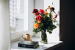 © ADDICTIVE STOCK - Bible and vibrant flowers on a sunlit windowsill