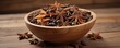 © Prapasarabhron - Wooden bowl filled with star anise on a rustic wooden table, nature-inspired, spice