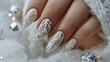 © Kharkovich - White nails with silver snowflake design surrounded by soft white fabric and shiny ornaments