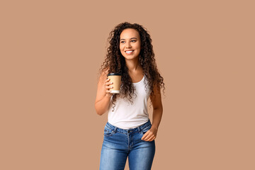 Poster - Happy young African-American woman with paper cup of coffee on beige background